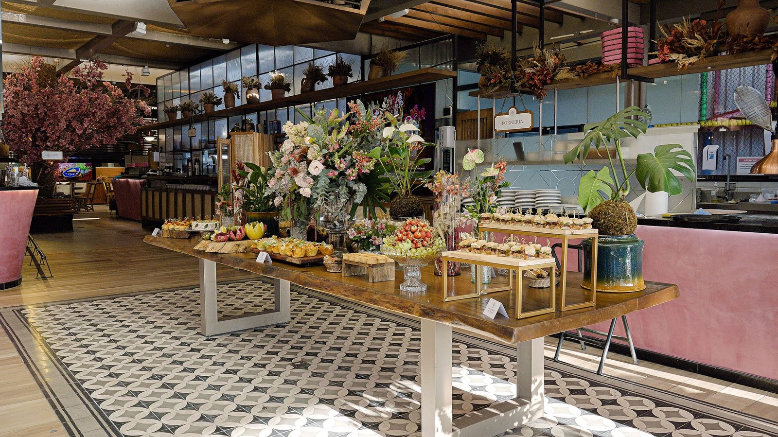 Estação de doces com grande arranjo de flores